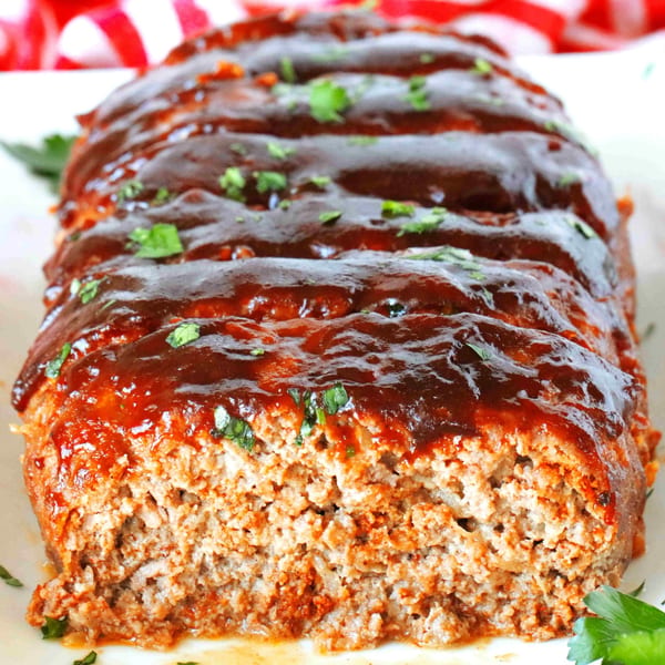 Phat Daddy's BBQ meatloaf, sliced and topped with rich barbecue sauce and fresh parsley.